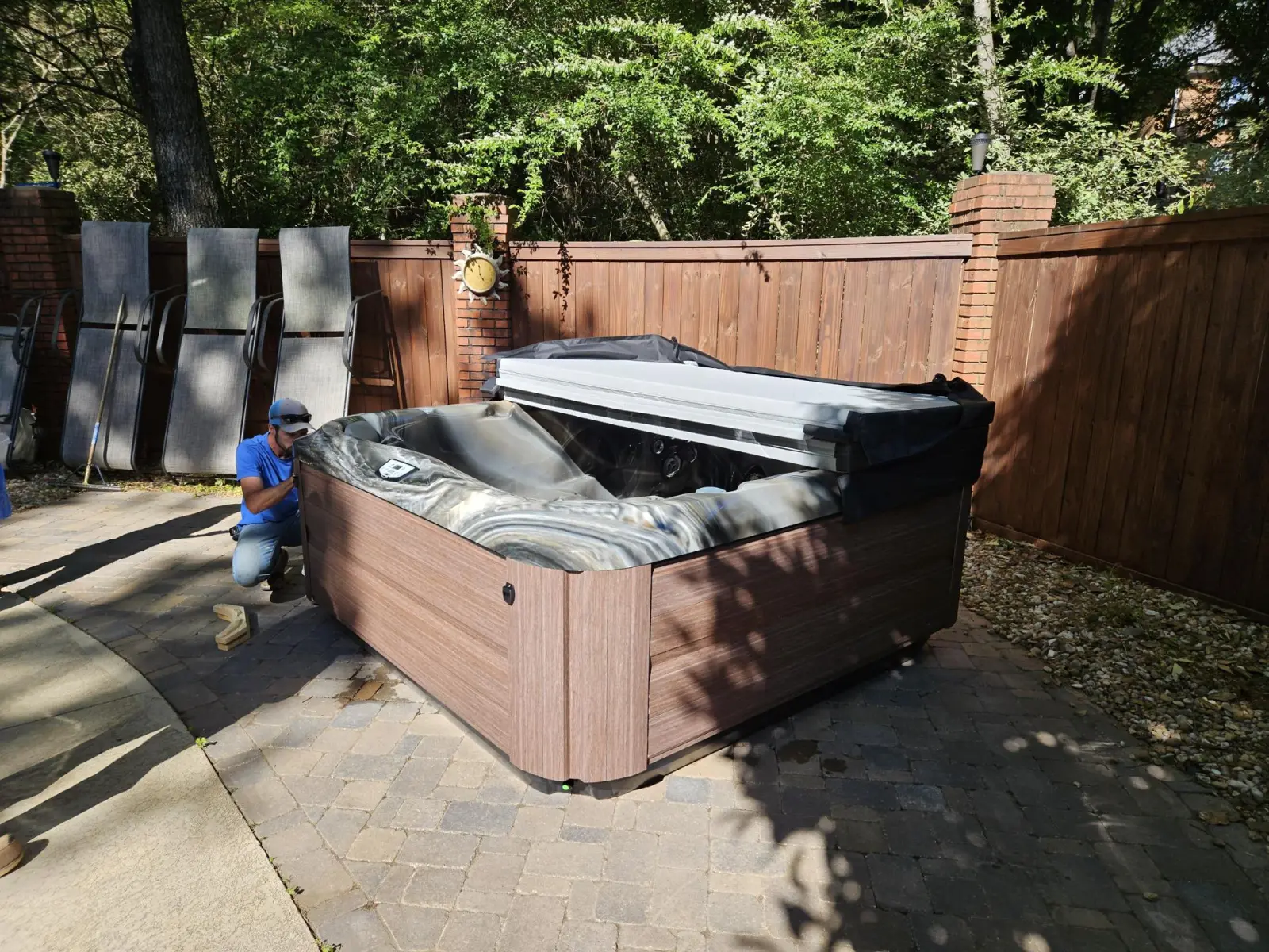 Hot tub being set on a patio by the installation crew