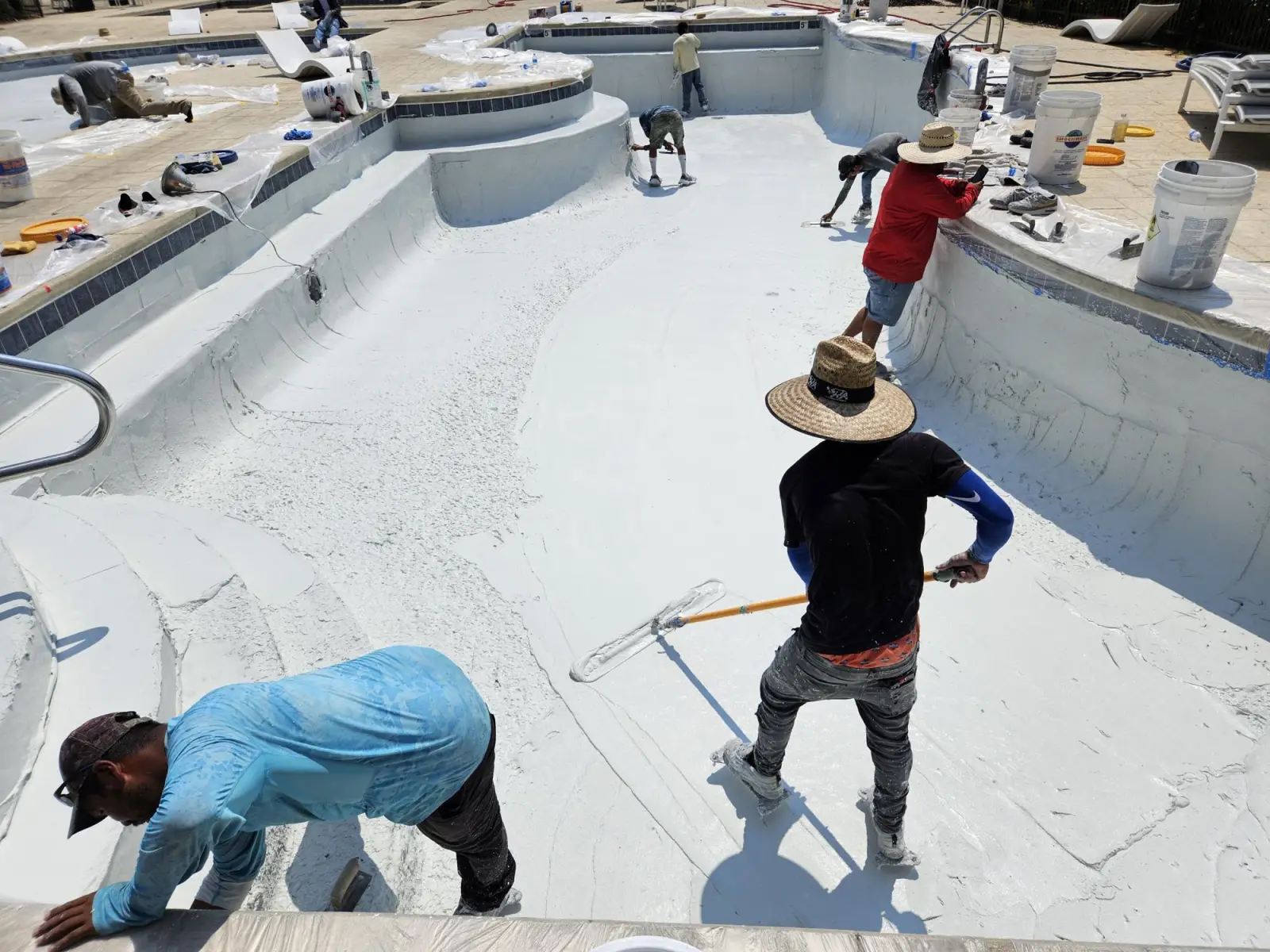 Crew replastering a large community pool in Birmingham